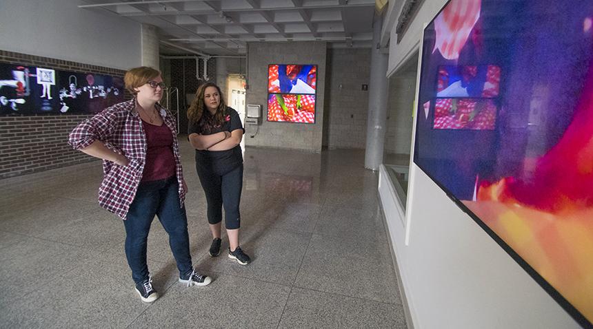两个学生在数字屏幕上观看艺术作品